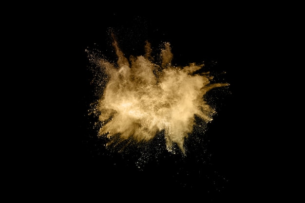 Explosión de polvo de oro sobre fondo negro. Congelar el movimiento.
