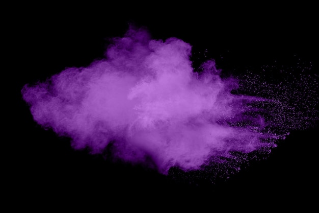 Explosión púrpura abstracta del polvo en fondo negro.