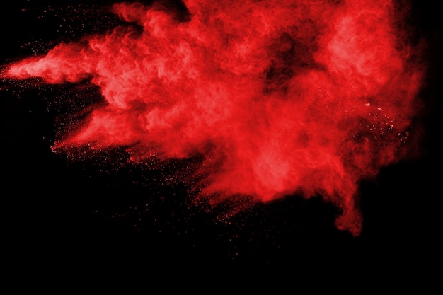 Explosión roja abstracta del polvo en fondo negro.