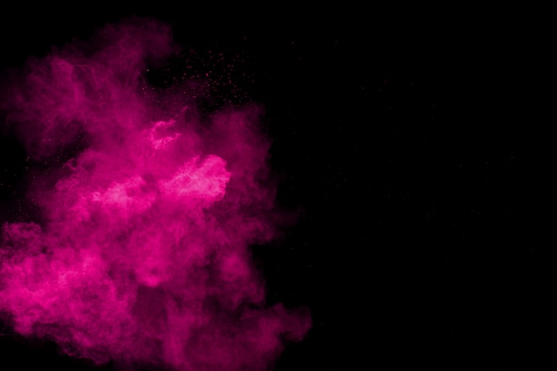Explosión rosada del polvo en fondo negro.