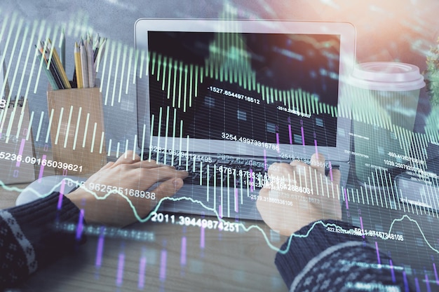 Exposição dupla de mãos de mulheres digitando no computador e diagrama de forex desenho de holograma conceito de investimento no mercado de ações