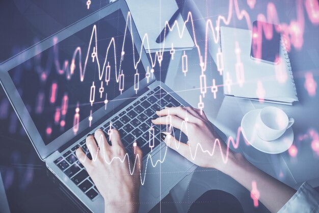 Exposição dupla de mãos de mulheres digitando no computador e diagrama de forex desenho de holograma conceito de investimento no mercado de ações