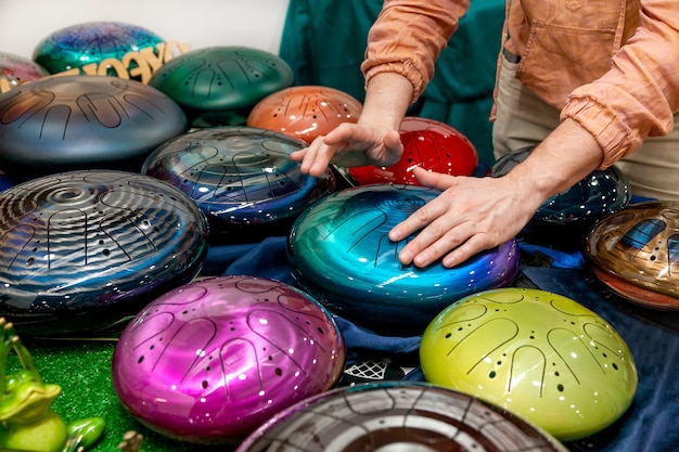 Exposição e venda de instrumentos musicais inusitados - tambor tanque. O homem joga um deles.