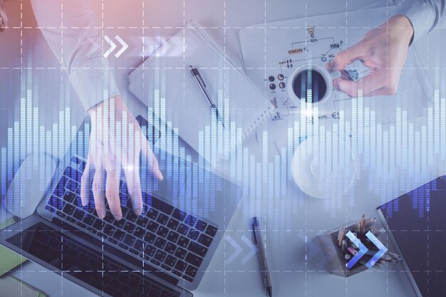 Exposição múltipla de mãos de homens digitando no teclado do computador e desenho de holograma de gráfico forex Visão superior Conceito de mercados financeiros