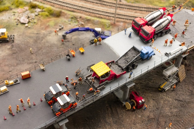 La exposición de Grand maket Rusia. Los trabajadores y los vehículos de servicio están construyendo un nuevo puente, un fragmento de un gran diseño autónomo en Rusia.