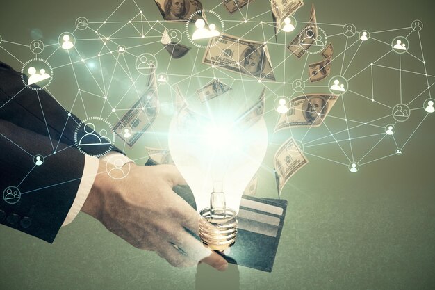 Exposición múltiple de bulbo dibujando holograma y billetes de dólares estadounidenses y manos de hombre Concepto de idea de negocio