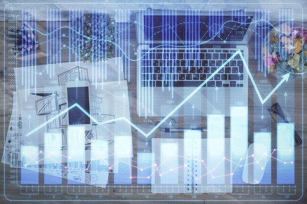 Exposición múltiple del dibujo del gráfico financiero sobre el fondo de la tabla con concepto de computadora de investigación Vista superior