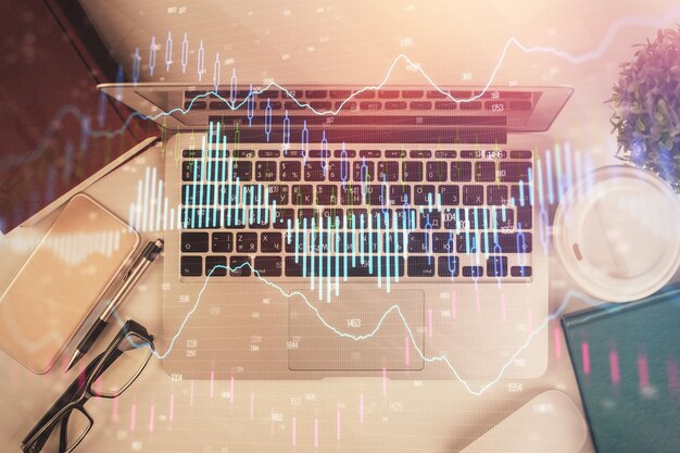 Exposición múltiple del dibujo del gráfico financiero sobre el fondo de la tabla con concepto de computadora de investigación Vista superior