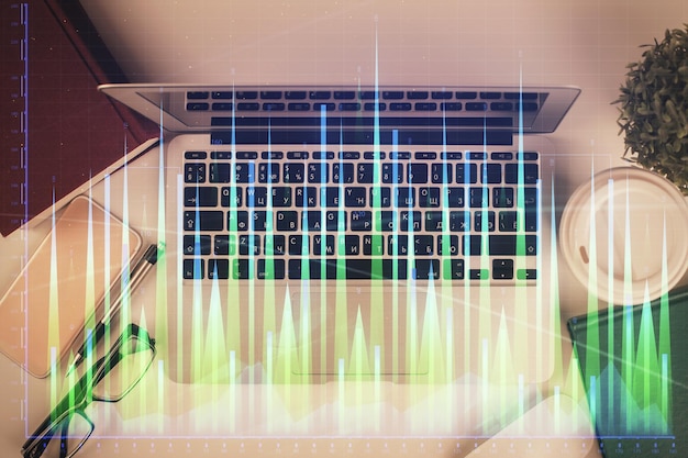 Exposición múltiple del dibujo del gráfico financiero sobre el fondo de la tabla con concepto de computadora de investigación Vista superior