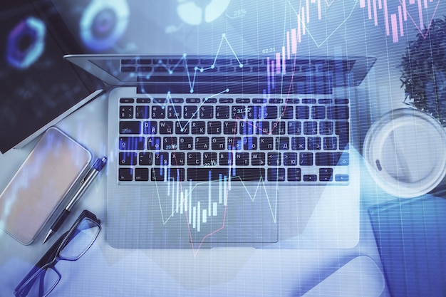 Exposición múltiple del dibujo del gráfico financiero sobre el fondo de la tabla con concepto de computadora de investigación Vista superior