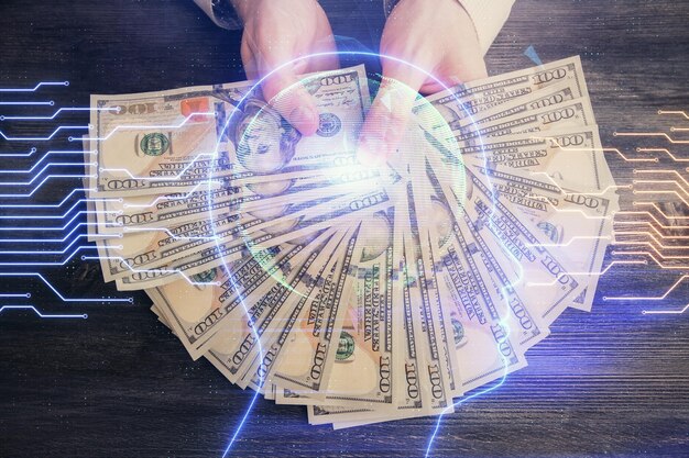 Exposición múltiple del holograma de dibujo cerebral y billetes de dólares estadounidenses y manos de hombre concepto de inversión Ai