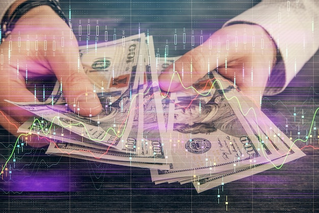 Exposición múltiple de holograma de dibujo de gráfico financiero y billetes de dólares estadounidenses y concepto de análisis de manos de hombre