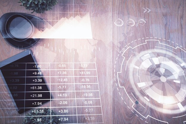 Exposición múltiple del holograma del gráfico financiero sobre el escritorio con el teléfono Vista superior Concepto de plataforma de comercio móvil