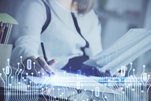 Exposición múltiple de la mano de escritura de una mujer sobre el fondo con tecnología de datos hud Concepto de big data