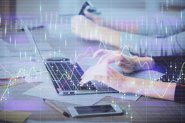Exposición múltiple de manos femeninas escribiendo en computadora y dibujo de hologramas de gráficos financieros Concepto de análisis del mercado de valores