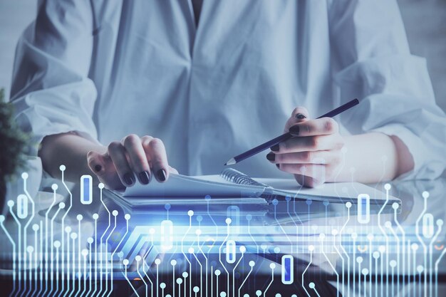 Exposición múltiple de las manos haciendo notas con iconos de codificación digital Concepto de aprendizaje por computadora