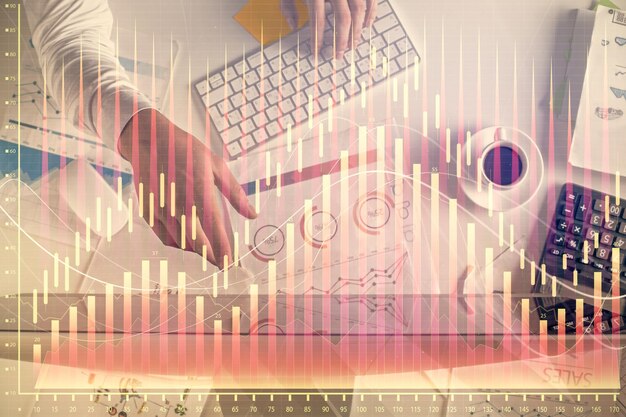 Exposición múltiple de las manos del hombre escribiendo en el teclado de la computadora y dibujo de hologramas de gráficos de divisas Vista superior Concepto de mercados financieros