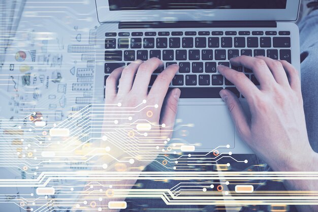 Exposición múltiple de las manos de los hombres escribiendo a través del teclado de la computadora y el dibujo de hologramas de datos Vista superior Concepto tecnológico