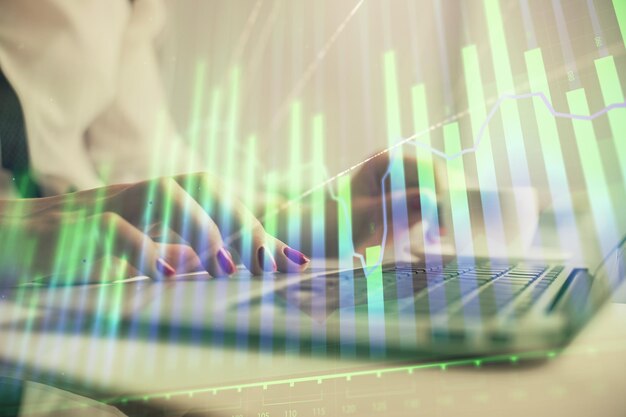 Exposición múltiple de manos de mujer escribiendo en computadora y dibujo de holograma gráfico financiero Concepto de análisis de mercado de valores