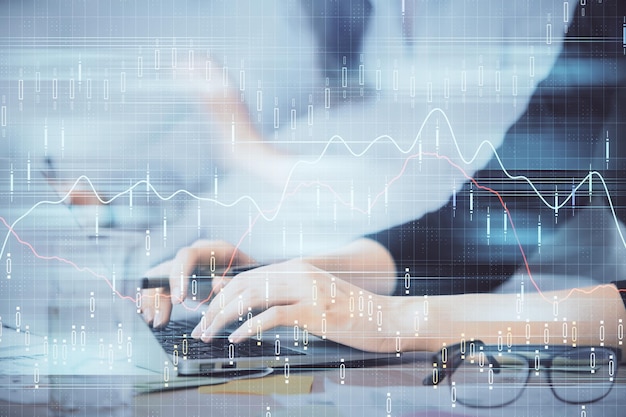 Exposición múltiple de manos de mujer escribiendo en computadora y gráfico financiero holograma dibujo concepto de análisis del mercado de valores