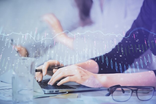 Exposición múltiple de manos de mujer escribiendo en computadora y gráfico financiero holograma dibujo concepto de análisis del mercado de valores
