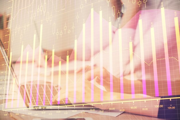 Exposición múltiple de manos de mujeres escribiendo en la computadora y dibujo de hologramas de gráficos financieros Concepto de análisis del mercado de valores