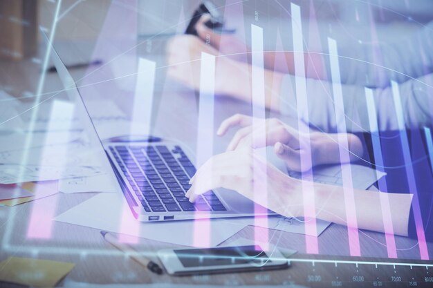 Exposición múltiple de manos de mujeres escribiendo en la computadora y dibujo de hologramas de gráficos financieros Concepto de análisis del mercado de valores
