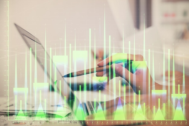Exposición múltiple de manos de mujeres escribiendo en computadora y dibujo de hologramas de gráficos financieros Concepto de análisis del mercado de valores