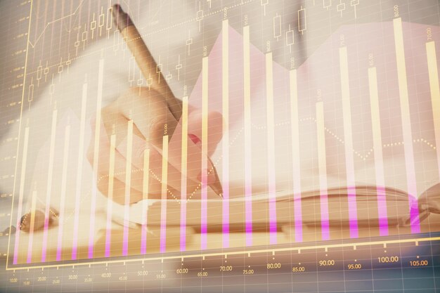 Exposición múltiple de las manos de las mujeres haciendo notas con holograma de gráfico de divisas Análisis conceptual del mercado de valores