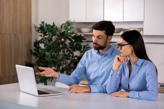 Exprese su idea Colegas profesionales usando su computadora portátil mientras trabajan en el proyecto