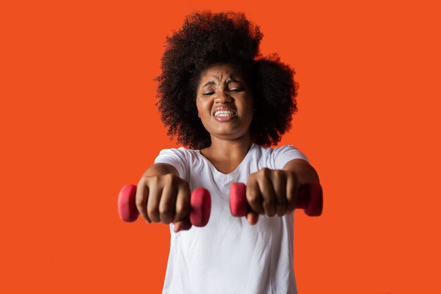 Expresión de entrenamiento duro con mancuernas de mujer africana