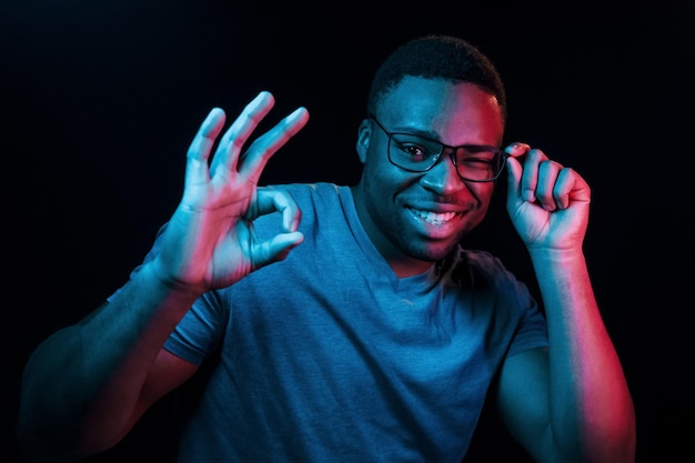 Expresión facial Iluminación de neón futurista Joven afroamericano en el estudio