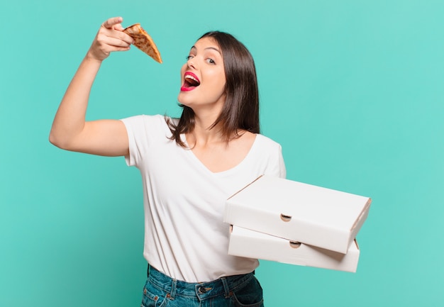 Expresión feliz joven mujer bonita y sosteniendo una pizza