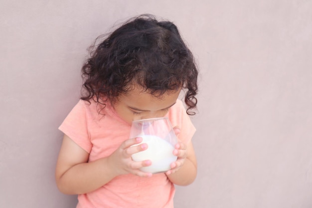 Expresión de una niña que bebe leche en un vaso