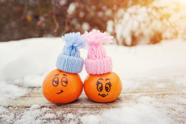 Expresiones faciales divertidas en las mandarinas en un sombreros azul y rosa