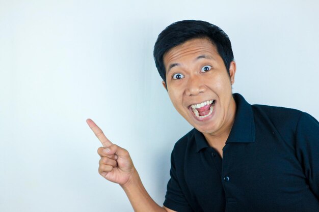 Foto expressão de homem asiático sorrindo enquanto aponta para o lado apresentando o conceito de publicidade do produto