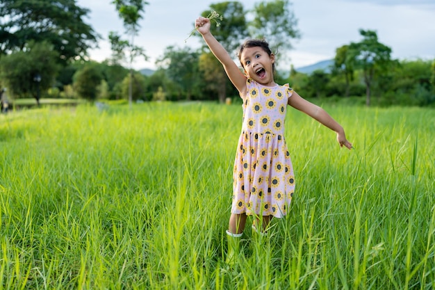 Expressão de rosto feliz menina no campo de grama.