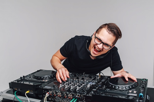 Expression DJ mit einem Mixer arbeitet auf einem Grau