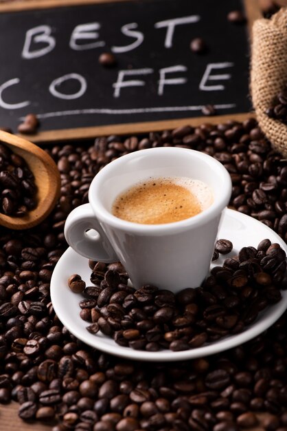 Expresso-Kaffeetasse Nahaufnahme über dunklen gerösteten Kaffeebohnen