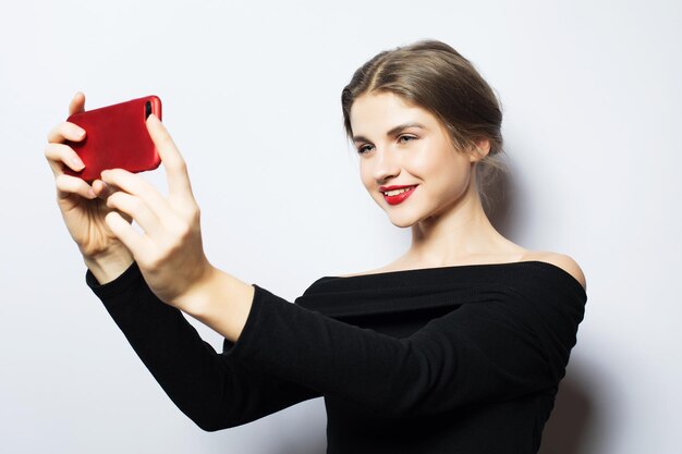 Expressões de emoções e conceito de pessoas feliz sorridente jovem vestindo vestido preto tomando selfie com smartphone