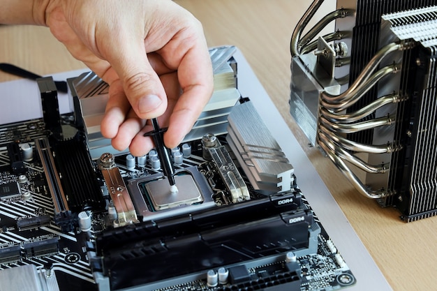 Foto exprime con la mano un poco de grasa térmica al procesador para obtener más compuesto con enfriador