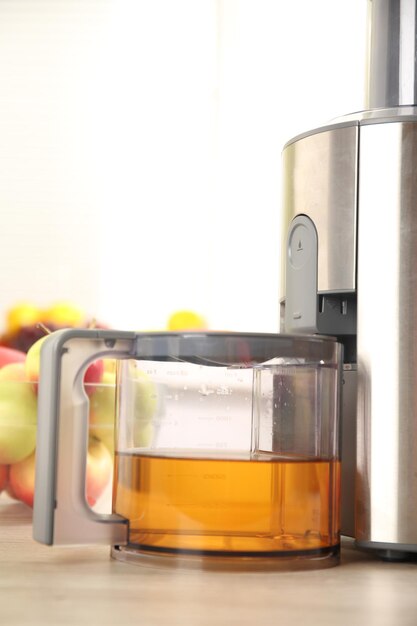 Exprimidor y jugo de manzana en la mesa de la cocina