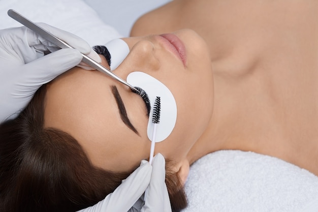 Extensões de cílios, Cílios postiços, Procedimento de extensão de cílios, Estilista profissional que alonga os cílios femininos, Mestre e cliente em um salão de beleza,