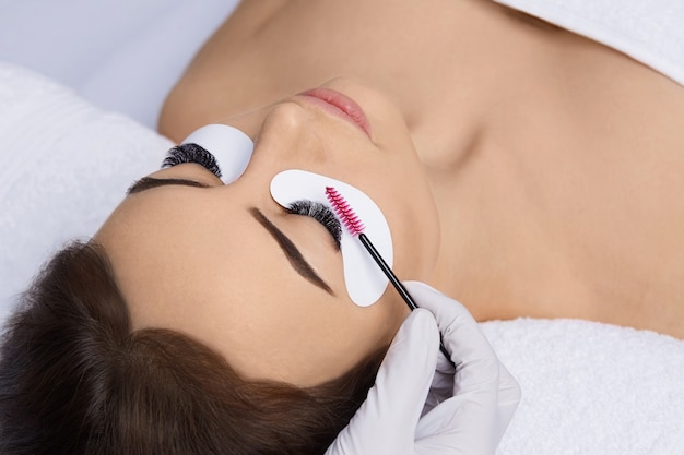 Extensões de cílios, Cílios postiços, Procedimento de extensão de cílios, Mestre e um cliente em um salão de beleza,