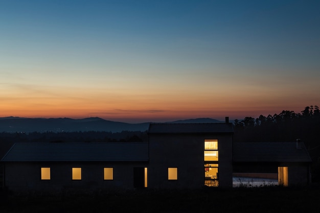Foto exterior de villa moderna à noite com fundo de montanha. foto noturna em villa contemporânea