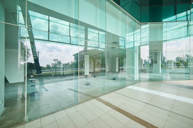 Foto exterior de un edificio de oficinas moderno de acero y vidrio verde con pasarela vacía. vista panorámica y en perspectiva. diseño de arquitecto abstracto, inspirador, artístico y moderno.