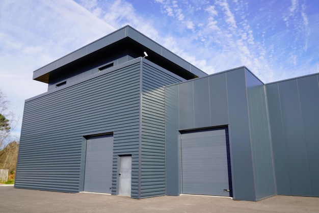 Exterior de hangar de almacén gris nuevo y moderno con puerta seccional gris