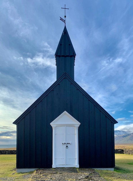 Exterior de la iglesia negra en el campo contra el cielo