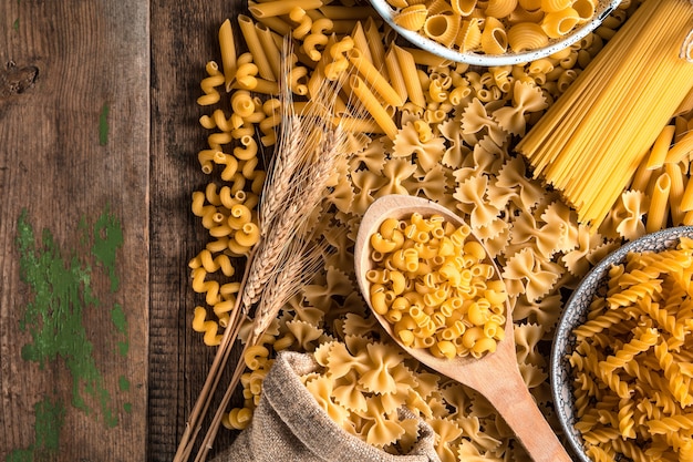 Extienda sobre una mesa de madera pasta de diferentes tipos.