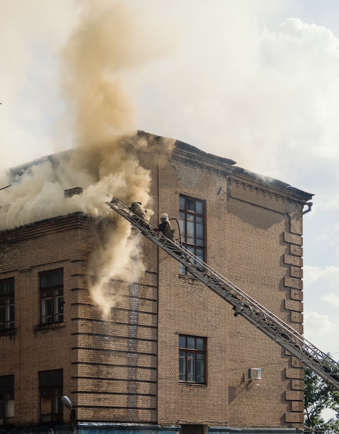 Extinción de un incendio en un antiguo edificio de tres pisos.